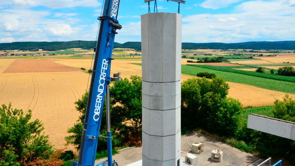 Turmbau einer Windanlage: Bei der neuen Methode werden die hohlen Beton-Doppelwandelemente mit Hilfe eines Krans aufeinander gestapelt und dann vor Ort mit Beton ausgegossen.