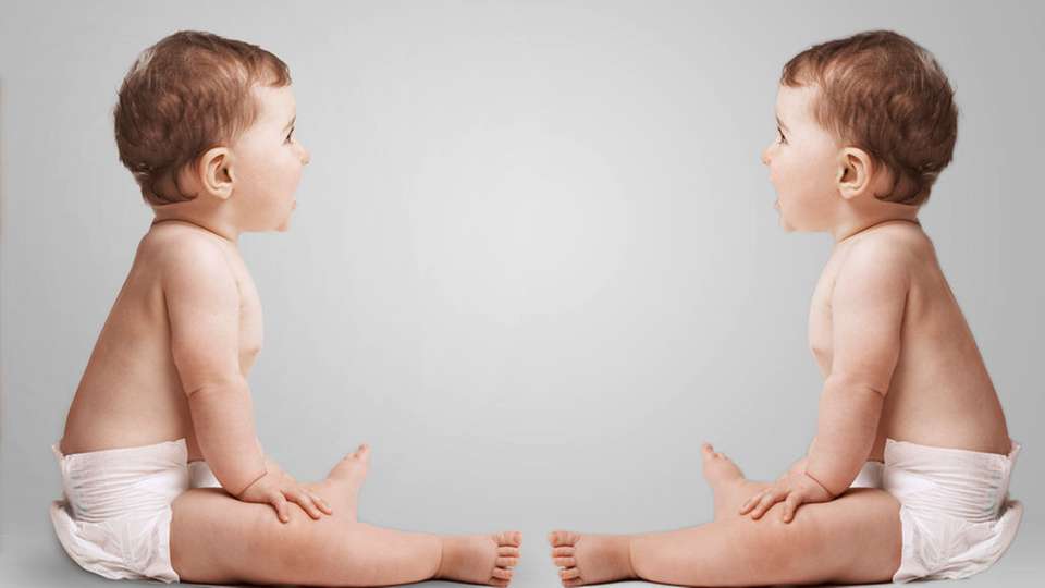 Identical twins looking at each other in studio