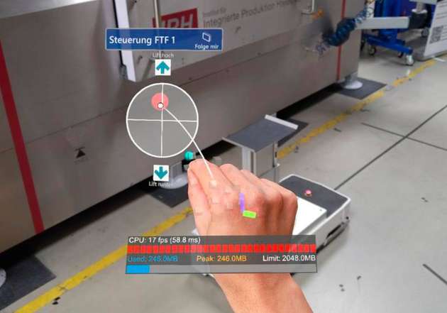 Blick durch die AR-Brille: Der Screenshot zeigt die Benutzeroberfläche für die Gestensteuerung. Logistikmitarbeiter müssen lediglich den roten Punkt greifen, der als virtueller Joystick dient um das Fahrzeug zu bewegen.
