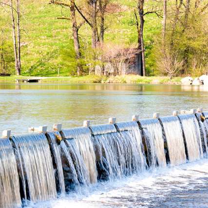Durch die Talsperre an der Loisach wird das Flusswasser für ein Wasserkraftwerk in Bayern aufgestaut.