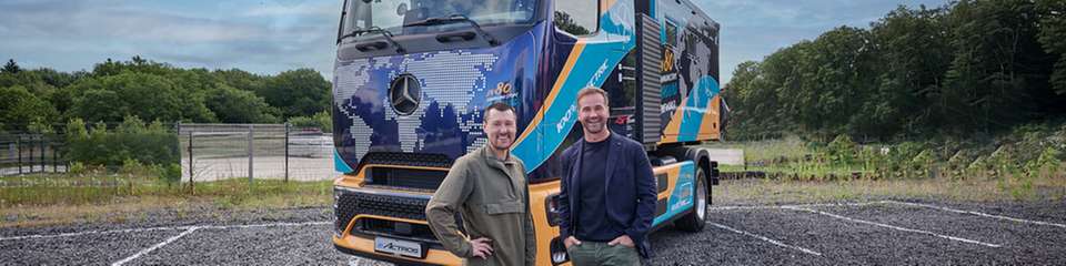 Tobias Wagner und Achim Puchert vor dem batterieelektrischen eActros 600, mit dem Wagner eine Weltumrundung plant.