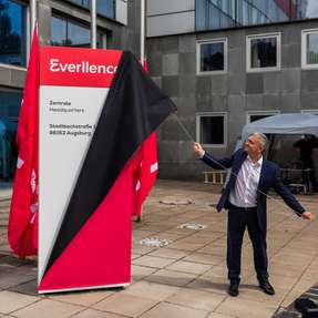 Uwe Lauber, CEO Everllence, enthüllt das neue Firmenlogo vor dem Augsburger Hauptquartier.