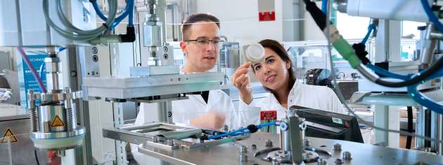 Experten des Fraunhofer IVV bei der Optimierung eines Verfahrens zur Produktion von Verpackungen.