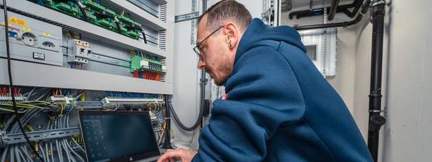 Ein Servicetechniker von Klima Kälte Kopp bei der Inbetriebnahme eines modernen Kühlanlagen-Systems: Über eine Software-Schnittstelle werden alle Funktionen der Anlage überwacht, parametriert und auf maximale Effizienz abgestimmt.