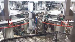 Die Blasmaschine produziert PET-Behälter im laufenden Prozess: Mit Preferential Heating lassen sich flache Top-Down-Flaschen für Saucen bei hoher Leistung fertigen und gleichzeitig Materialeinsatz sowie Energiebedarf reduzieren.