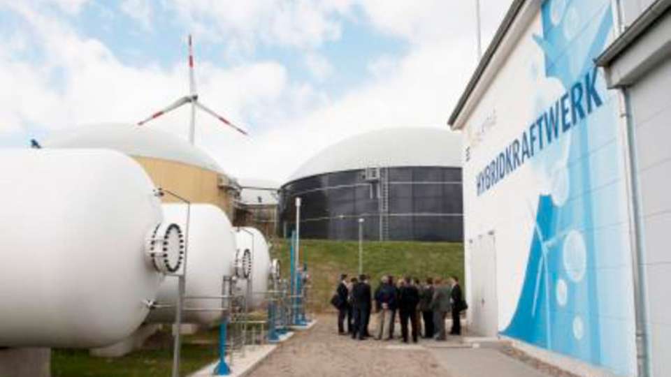 
                        
                        
                          Hohes Besucherinteresse: In der Prototyp-Anlage von Enertrag in Prenzlau generiert ein Elektrolyseur (in der Halle rechts) mit überschüssigem Windkraftstrom Wasserstoff, der in den Tanks links gespeichert wird.
                        
                      
