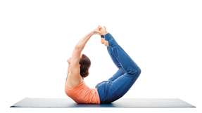 Sporty fit woman practices yoga asana Dhanurasana