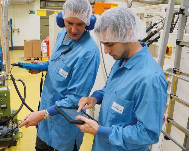 Während Heiko Leonhardt (links) mit Hilfe eines Ultraschallmessgeräts die Leckagen ortet, erfasst Manuel Stephan (rechts) die Messwerte auf dem Tablet.