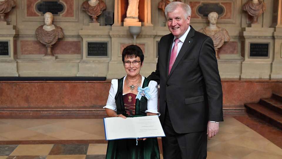 Horst Seehofer überreicht Katharina Wiedemann den Orden und die Urkunde.