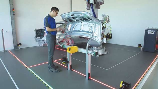 Der Roboter fixiert das Werkstück und ist im sicheren Halt, während die Scharniere manuell befestigt werden.