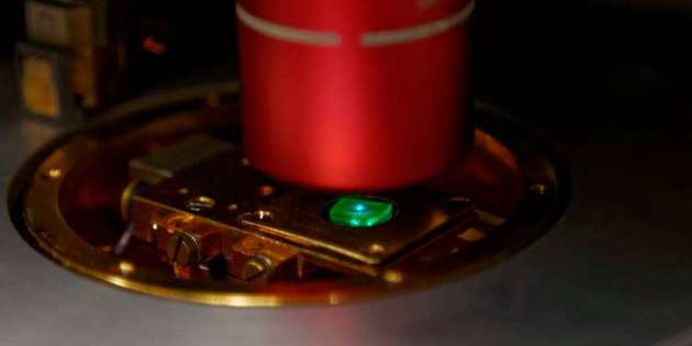 Eine Probe mit mehreren grün leuchtenden Perowskit-Quantenpunkten, die von einem blauen Laser angeregt werden.