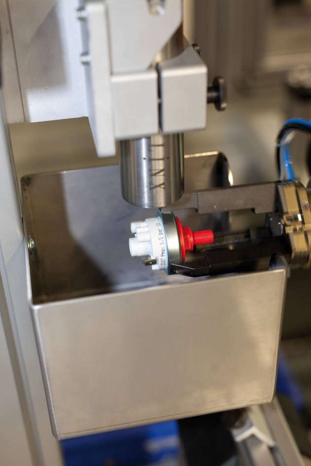 Ein Roboterarm führt das Produkt in einer 360-Grad-Drehung am Druckkopf entlang.