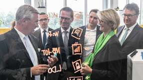 Prof. Dr. Michael ten Hompel von der TU Dortmund (links) zeigt Bundesministerin Karliczek (2.v.r.) den IoT Service Button.