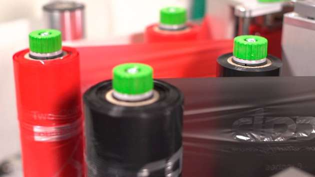 Rote und schwarze Thermotransferfolie. Durch das Erhitzen im Thermotransferverfahren schmilzt die Farbschicht der Folie und überträgt sich auf das Etikett.