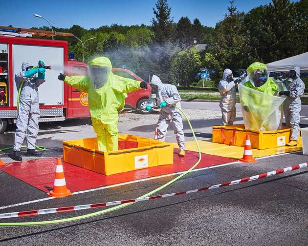 Die Dekontamination folgt einem festen Prozedere: Erst wird der kontaminierte Schutzanzug abgespritzt, dann verlässt die Einsatzkraft in einer zweiten Schleuse den Anzug. Er wird zur Entsorgung einer auf Sondermüll spezialisierten Firma übergeben.