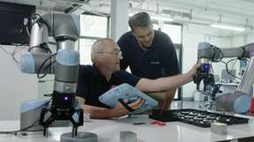 Peter Härtel und Jörg Lang programmieren die Roboter bei Beyerdynamic im „Teach Modus“. Dank diesem kann ein Anwender den Roboterarm greifen und ihm neue Aufgaben beibringen, indem er ihn per Hand von Wegpunkt zu Wegpunkt führt.