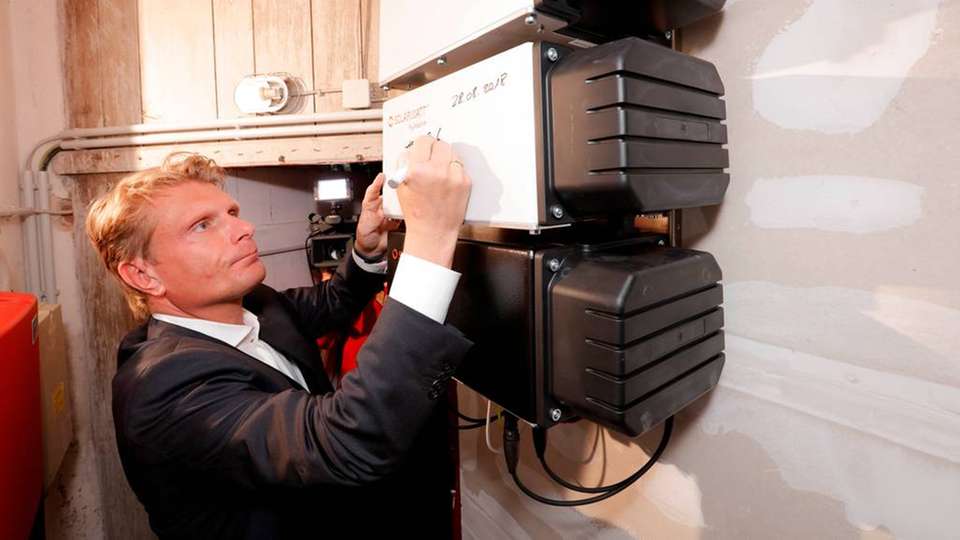 Thomas Bareiß vom Bundesministerium für Wirtschaft und Energie nimmt den 100.000sten Solarspeicher in Deutschland offiziell in Betrieb.