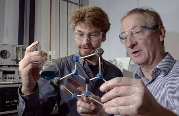 Doktorand Benjamin Kintzel (links) und Prof. Dr. Winfried Plass diskutieren über das von ihnen entwickelte Molekül.
