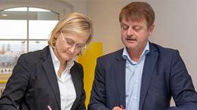 Susanne Heger, Geschäftsführerin der T-Systems Multimedia Solutions und Frank Schönefeld, Mitglied der Geschäftsleitung von T-Systems Multimedia Solutions und Sprecher der Taskforce Smart Systems Hub, bei der Unterzeichnung des Kooperationsvertrages.