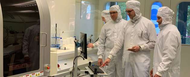 Die Professoren Nils Weimann (links) und Andreas Stöhr (rechts) mit Mitarbeiter Christian Blumberg an einer Anlage zur Halbleiterintegration. Diese steht im Reinraum des Zentrums für Halbleitertechnik und Optoelektronik der UDE.