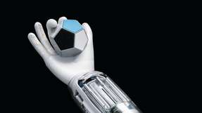 Die BionicSoftHand kann einen zwölfseitigen Würfel so drehen, dass am Ende eine vorher festgelegte Seite nach oben zeigt. Die richtige Vorgehensweise erlernt sie durch das Trial-and-Error-Prinzip.