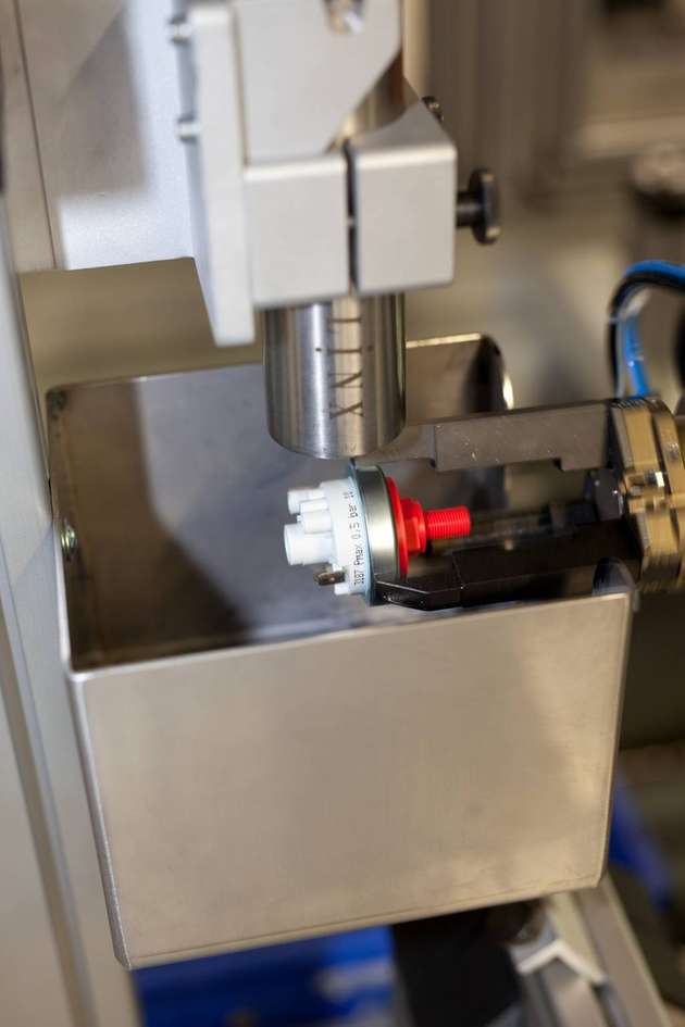 Robotergestützte Kennzeichnung: Ein Roboter reicht dem Kennzeichnungssystem das Produkt an.