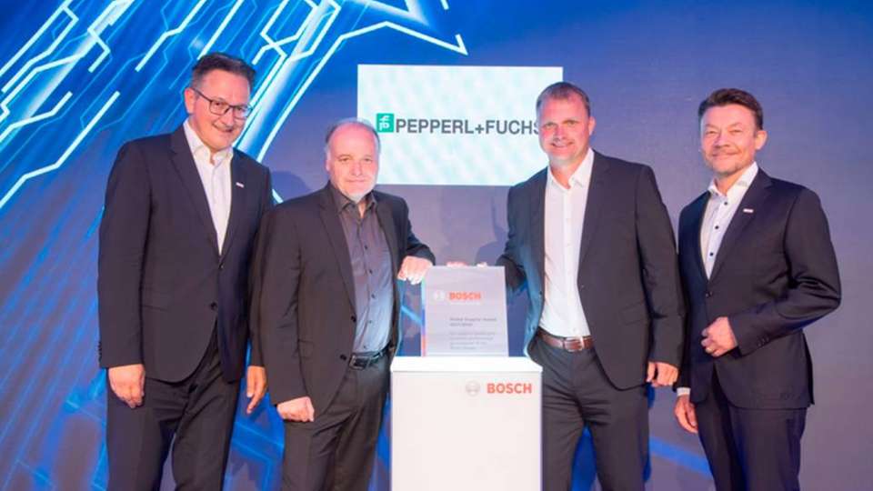 Pepperl+Fuchs-CEO Dr. Gunther Kegel (zweiter von links) und Global Key Account Manager Bernd Fischer (zweiter von rechts) nehmen erfreut den Preis für Pepperl+Fuchs entgegen.
