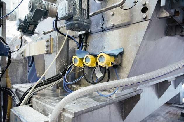 Robuste Sensoren wie der Vegabar 82 (links im Bild) sind gefragt, wenn zuverlässige Messwerte in rauen Umgebungen benötigt werden. Denn Vibrationen, Dampf und Feuchte gehören zum Alltag in der Papierproduktion (rechts).