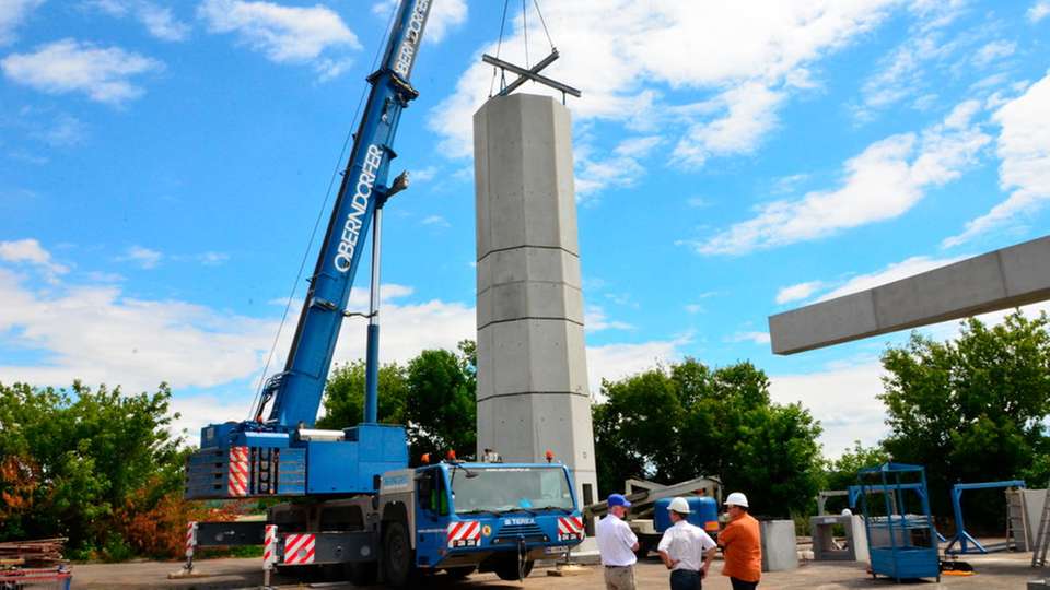 Vor-Ort-Fertigstellung: Die hohlen Beton-Doppelwandelemente werden mit Hilfe eines Krans exakt aufeinander gestapelt und dann mit Beton ausgegossen.