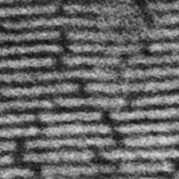 Eine elektronenmikroskopische Aufnahme zeigt die nebeneinander und übereinander angeordneten Nanoplättchen (hell) mit dazwischenliegender isolierender Quantenbarriere (dunkel) im Querschnitt.