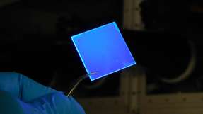 Eine mit mehreren Lagen Halbleiter-Nanoplättchen beschichtete Glasscheibe beginnt im UV-Licht, blau zu leuchten.