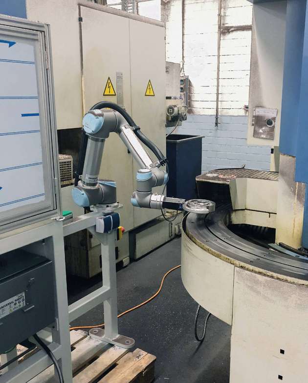 Der Roboter mit dem Greifer der Zimmer Group übernimmt den Transport des Bauteils zwischen der ersten und der zweiten Bearbeitungsmaschine sowie hin zur Nadelprägung.