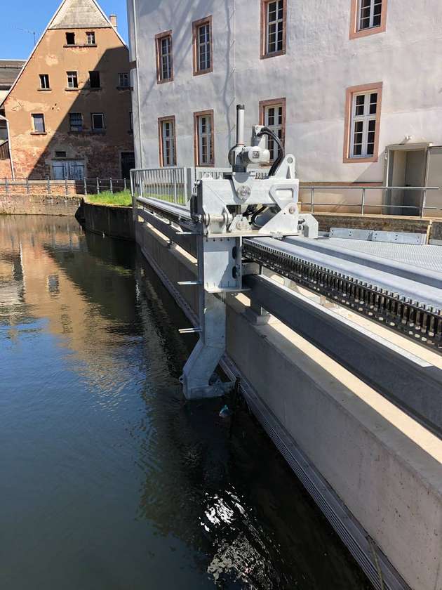 Der Reinigungsarm fährt horizontal am Rechen entlang und schiebt Schwemmgut in den Abflusskanal. Dabei muss der Verfahrwagen mit Strom und Signalen versorgt werden.