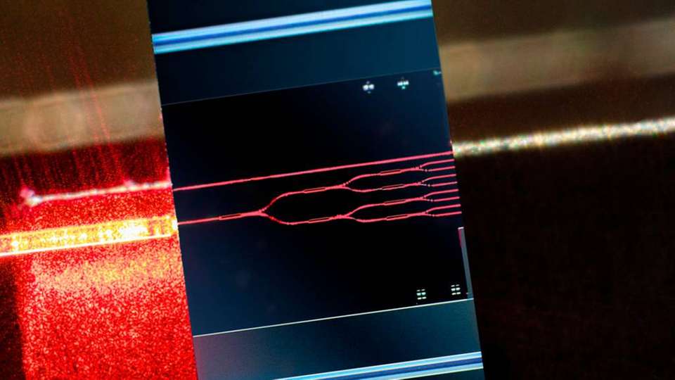 Test-Kit für hochgenaue selbst-ausrichtende Montagetechnologie zur Integration von Lichtquellen und Detektoren mit photonischen integrierten Schaltungen. Rotes Licht: geflutete photonisch integrierte Schaltung als Testvehikel.