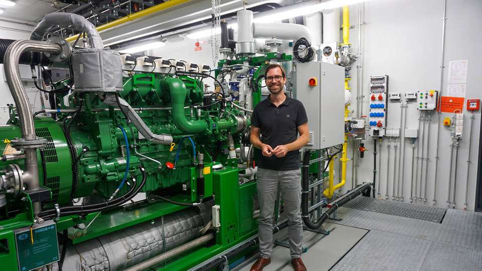 Prof. Dr. Raphael Lechner zeigt eines der Blockheizkraftwerke am Kompetenzzentrum für Kraft-Wärme-Kopplung.