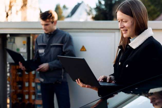 Katrin Schulte lässt sich von Marco Sawatzki vom Netzbetreiber Westfalen Weser Netz die digitale Hardware zur Aufnahme von Niederspannungs-Messdaten in einer Ortsnetzstation zeigen.