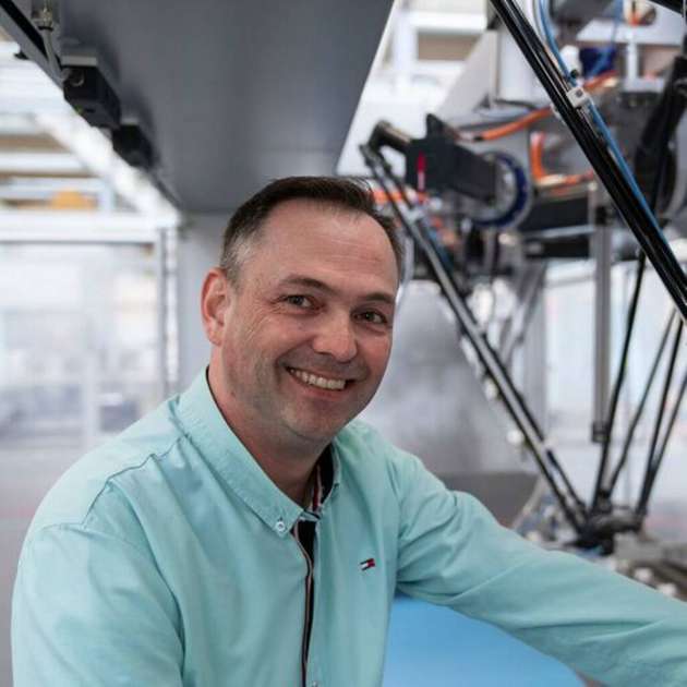 Andreas Schildknecht, Produktmanager Robotik bei Syntegon, mit einem Deltaroboter im Hintergrund