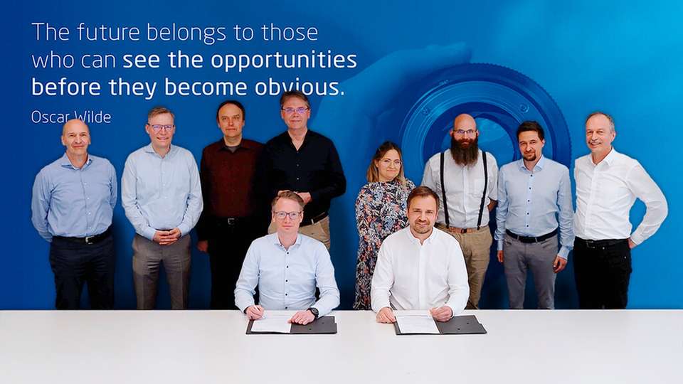 Vertragsunterzeichnung durch Christoph Hartung (vorne links), Vorsitzender der Geschäftsführung von Etas, und Stefan Krassin (vorne rechts), Geschäftsführer und CEO von PLC2 Design