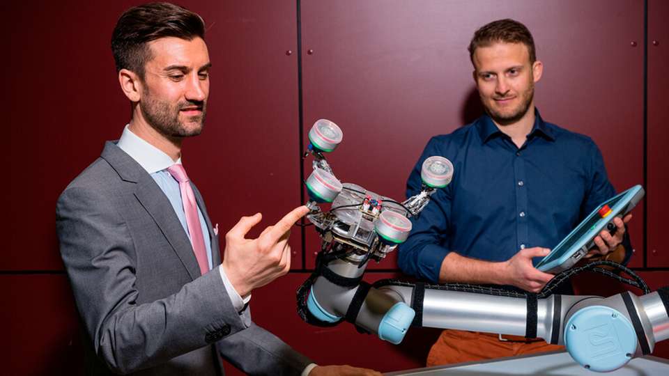 Der Robotersauggreifer des Teams von Prof. Stefan Seelecke kann kompliziert geformte Werkstücke greifen und sich wechselnden Formen anpassen. Dr. Paul Motzki (l.) und Lukas Zimmer (r.) haben das System mitentwickelt.