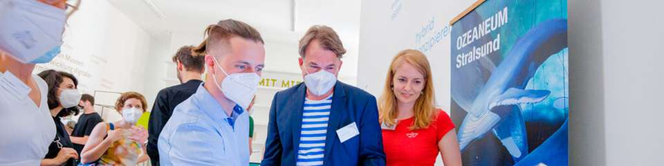 Marco Kircher, Wissenschaftler am Fraunhofer IPMS, zeigt Karsten Goletz und Anke Neumeister vom Projektteam „museum4punkt0“ am Deutschen Meeresmuseum, wie er mit Gesten einen virtuellen Pinguin steuert.