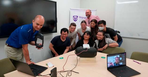 Dr. Adam Sirek richtet eine holografische Teleportation ein mit (untere Reihe) Alex Zhou, Hira Nadeem, Paula Bosca, (mittlere Reihe) Adam Levschuk, Jocelyn Whittal, Sara Mohamed, Jin Sing Sa und (oben) Douglas Keddy.