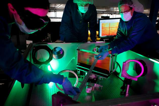 (Von links) Laseringenieurin Lauren Weinberg, Forschungswissenschaftler John Nees und Forschungsingenieurin Galina Kalinchenko posieren für Fotos bei der Arbeit am ZEUS-Laser in der NSF ZEUS-Laseranlage in einem Labor von Michigan Engineering.