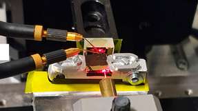 Ein roter Laser wurde verwendet, um den Strahlengang von der Faser in den Lichtwellenleiter und die Reflexion an einem Goldspiegel sichtbar zu machen. Die zwei Mikrosonden kontaktieren den Fotoleiter, der eine Größe im Subwellenlängenbereich aufweist.