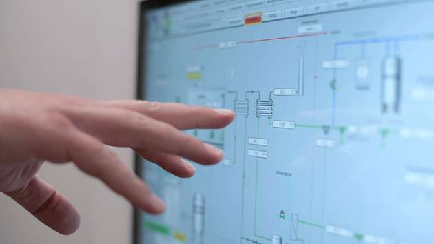 Das Energiemanagementsystem erfasst und visualisiert alle Komponenten. Die Hand zeigt auf die Heizpatronen. 