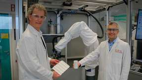 Prof. Dr. Dominik Henrich (links) und Prof. Stefan Schafföner vor einer Roboterzelle zur Herstellung von Bauteilen aus Faserverbundwerkstoffen