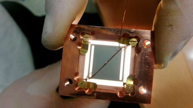 Der Mikrowellen-Resonator besteht aus zwei supraleitenden Chips in eine Sandwich Konfiguration, mit dem kleinen Diamant Steinchen in der Mitte.