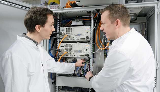 Rune Callesen (links), Leiter der Automatisierungsabteilung von Elos Medtech, und Rasmus Jensen (rechts), Support-Ingenieur von Beckhoff Dänemark, vor dem Schaltschrank der Blisterverpackungsmaschine, die künftig auch die Kartonverpackung übernehmen wird. 