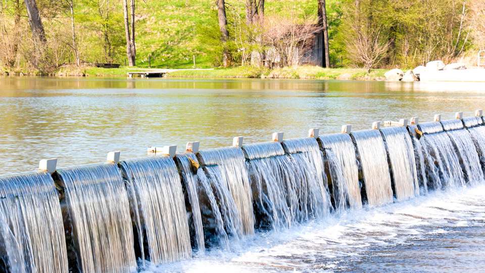 Durch die Talsperre an der Loisach wird das Flusswasser für ein Wasserkraftwerk in Bayern aufgestaut.