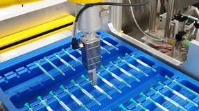 Der kleinste vollintegrierte Servogreifer der Welt führt in der Etikettierzelle 211 HC RC nicht-standsichere Pharmaprodukte wie etwa Spritzen vom Tray sicher in die Etikettierstation, dann unter die Kontrollkamera und wieder ins Tray.