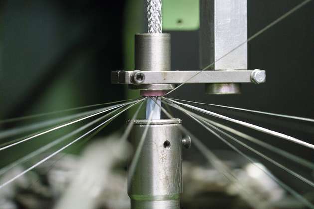 Eine Isolationsschicht wird um die Kabelseele herum verseilt.